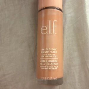 e.l.f. Halo Glow Liquid Filter - Säljer en e.l.f. Halo Glow Liquid Filter som ger en strålande och jämn hudton. Den innehåller squalane och hyaluronsyra för extra fukt och lyster. Perfekt för att skapa en naturlig glow eller som bas under smink. Flaskan innehåller 31,5 ml. Mycket kvar, färg 3 medium, kan se mörk ut men blir betydligt  ljusare på
