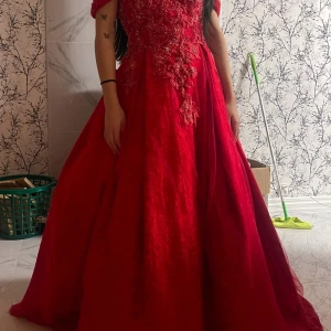 Röd balklänning - Röd balklänning som passar båda xs-L då den är justerbar i ryggen med hjälp av snören som man kan spänna åt.💗Man får även med underkjol och handskar🥰Går även att ta bort banden vid axlarna