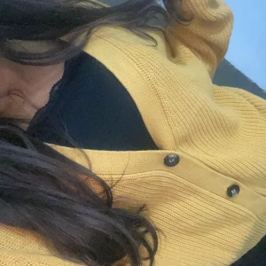 Gul stickad kofta - Säljer en mysig gul stickad kofta med knappar framtill. Perfekt för höst och vinter, den har långa ärmar och en skön passform. Superfin att ha över en t-shirt eller blus för extra värme. 🧡