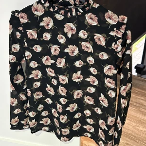 Blus - Blus från Ichi använd 2 gånger. I fin blommig mönster med svart och beige färger. Mycket bra skick!