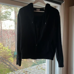 Svart Kashmir zip - Säljer en svart hoodie ikashmir. Den har en dragkedja framtill och är perfekt för både höst och vinter. Tröjan är i mycket bra skick och har långa ärmar samt en mysig huva. Kom med prisförslag om ni vill😊