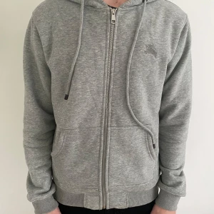 Grå Hoodie - Säljer en burbery hoodie i färgen grå. OBS inte ”äkta”. Köpte den här på Plick men den passade inte riktigt som jag ville. Den är i storleken M. Modellen på bilden är 180 och väger cirka 70 kg. Hör av er vid funderingar eller om du vill ha fler bilder. 