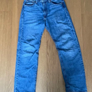 Blå jeans från Levi's - Säljer ett par klassiska blå jeans från Levi's i bra skick. De har en straight passform och är tillverkade i slitstarkt denim. matchas med nästan vad som helst. Har den ikoniska Levi's-lappen baktill. Passar både höst och vår! Endast använda vid 2 tillfällen w 30 L32