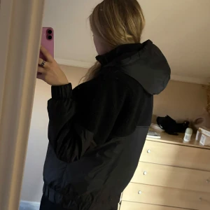 Svart anorak med huva - Svart snygg jacka/anorak från Urban Classics, knappt använd. Skön jacka att ha när man är ute och joggar/springer på vintern. Lite vadderad. Storlek L men väldigt liten i storlek, har storlek S och den passar mig perfekt. Praktiska fickor och huva✨