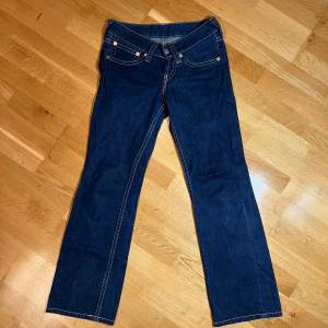 Säljer ett par klassiska Levi's jeans i blå denim. De har en snygg smal bootcut passform och är i mycket bra skick. Modell 921, lådmidjade.  Perfekta för både vardag och fest! 🕺