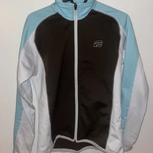 Sportig jacka från Everest - Säljer en sportig jacka från Everest i mycket bra skick. Den har en snygg färgkombination av mörkbrunt, vitt och ljusblått. Jackan är långärmad med dragkedja framtill och passar perfekt för träning eller som en lättare vårjacka💕💕