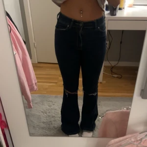 Mörkblå bootcut jeans - Säljer ett par mörkblå bootcut jeans i bra skick. De är högmidjade och har snygga slitningar på benen. Perfekta och jätte fina, använder ej dem.🌸