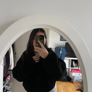 Svart teddyjacka - Mysig svart teddyjacka perfekt för kyliga dagar. Den har en dragkedja framtill och är långärmad. Jackan är i bra skick och passar perfekt för höst och vinter. Den är både stilren och bekväm, vilket gör den till ett måste i garderoben!