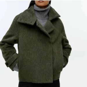 Arket kappa - Säljer en snygg olivgrön kappa i en italiensk ullblandning med luddig textur. Lös passform och hög ståkrage. Dold knäppning fram och flikar med knäppning vid ärmsluten. Helfodrad. Använd fåtal gånger som ny🩷🩷