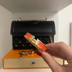 Orange och guld armband - Snyggt armband i orange och guld med en elegant design. Perfekt för att ge en färgklick till din outfit. Passar både till vardags och festliga tillfällen. Ett måste för den stilmedvetna!