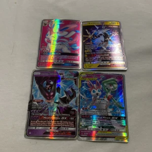 Pokémon GX-kort - Säljer fyra Pokémon GX-kort med holografisk effekt. Korten har färgglada och detaljerade illustrationer av olika Pokémon-karaktärer. Perfekt för samlare eller Pokémon-entusiaster som vill utöka sin samling.