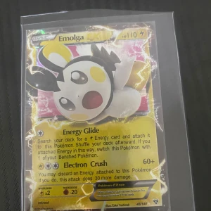 Pokémonkort Emolga - Säljer ett Pokémonkort med Emolga. Kortet har en glansig yta och visar Emolga i en dynamisk pose. Det har attacker som Energy Glide och Electron Crush. Perfekt för samlare eller spelare som vill förstärka sin kortlek.