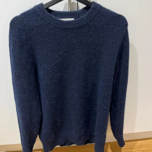 Mörkblå ulltröja från Selected Homme - Säljer en stilren mörkblå tröja från Selected Homme. Tröjan är tillverkad i mjuk ull och har en klassisk rund halsringning. Passar främst dig med M i storlek (jag har det själv).