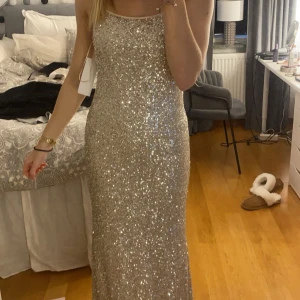 Glittrig balklänning i champagne  - Säljer min jättefina balklänning med prislappen kvar! Den är glittrig i färgen champagne med smala axelband och öppen rygg! Köpt för 1600kr men säljer nu för 1200kr! 