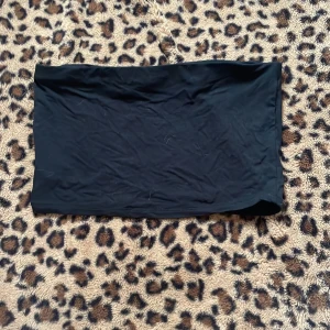 Svart tubtopp - Snygg svart tubtopp perfekt för en stilren look. Enkel design som passar till många olika outfits. 