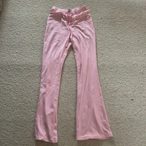 Rosa byxor med utsvängda ben - Snygga rosa byxor med utsvängda ben och hög midja. Perfekta för en trendig look. Tillverkade i ett mjukt och bekvämt material.