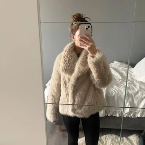 Beige pälsjacka - Säljer en supermjuk och fluffig beige pälsjacka med långa ärmar. Perfekt för att hålla sig varm och stilren under kyliga dagar. Jackan har en klassisk design med en lyxig känsla. Passar perfekt för vinterns alla äventyr.