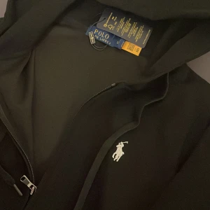 Polo Ralph Lauren - Säljer denna zip up Polo Ralph Lauren, helt ny! Storlek S men räkna med att den är mindre än S!!! Vid frågor skriv Dm!!! Finns byxor också men är väldigt små, skriv om du vill se de!! Ej äkta!