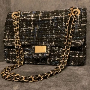 Svart glittrig axelväska med kedja - Snygg svart axelväska med glittrigt mönster och guldfärgad kedja. Jätte fin till våren 