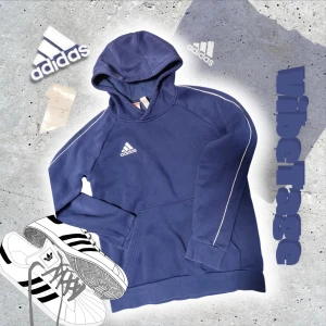 Blå hoodie från Adidas - Säljer en snygg blå hoodie från Adidas med vit logga på bröstet och vita detaljer längst armarna. Tröjan har långa ärmar och en praktisk magficka. Använd ett par gånger men i perfekt skick med absolut inga defekter. Pris kan rekommenderas och i storlek 164. 