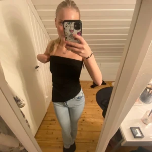 Svart tubtopp - Snygg svart tubtopp i ett stretchigt material. Perfekt för en stilren look och kan enkelt matchas med olika outfits. Toppen är axelbandslös och har en tight passform.