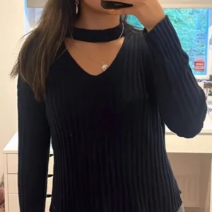 Svart ribbad tröja med v-ringning - Snygg svart ribbad tröja med v-ringning och långärmad design. Perfekt för en stilren look. Passar bra till både jeans och kjol.