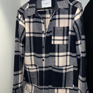 Overshirt i ull från Les Deux i S - Snygg rutig overshirt från Les Deux i beige och mörkblått. Storlek S. Nypris 2500kr. Använd 1-2 ggr.