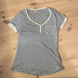 Randig t-shirt  - Blå och vit randig t-shirt från bikbok. Har ett litet hål i armen som jag tror lätt kan sys igen