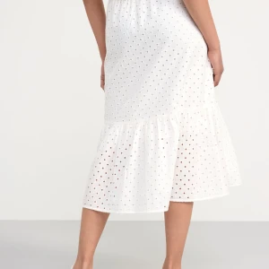 Vit kjol från Lindex - Säljer en söt vit kjol från Lindex med broderade detaljer och knappar framtill. Kjolen har en volangkant och är perfekt för varmare dagar. Den är tillverkad i ett lätt och luftigt material.