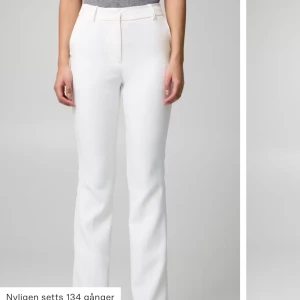 Vita kostymbyxor  - Vita kostymbyxor från Bikbok i storlek 40. De är högmidjade och i modellen ”Vilma”. Det finns en liten grå fläck vid ena knät. Nypris 499kr