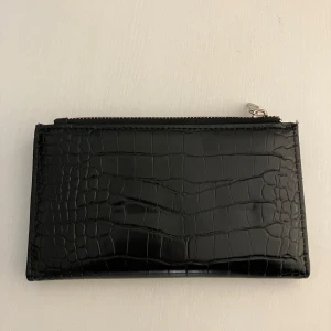 Plånbok i fejkläder - Inköpt på New Yorker för några år sedan, i bra skick! Finns massa kortfickor och en stor dragkedjeficka. 