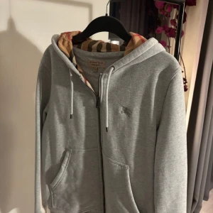 Grå hoodie från Burberry - Hej, säljer en snygg zip hoodie från burrberry,använd 2-3 gg, hör av er vid intresse och pris kan diskuteras vid snabb affär 