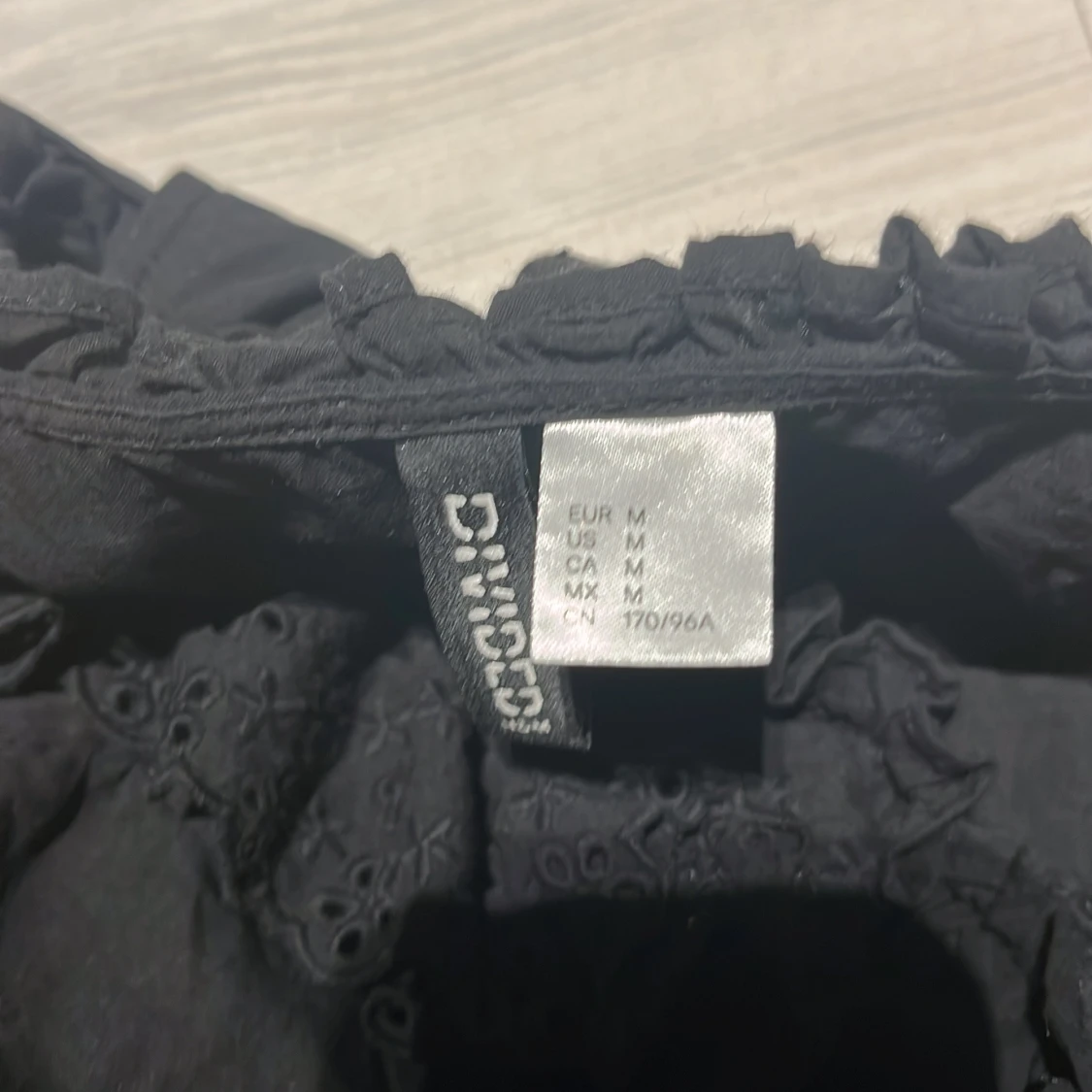 Svart blus med volangdetaljer - 91