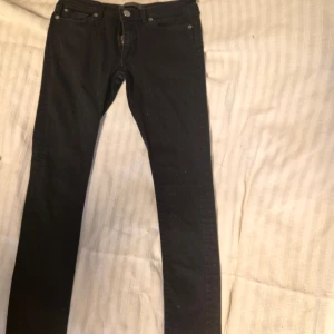 Svarta jeansbyxor - Snygga svarta jeansbyxor i slim fit. Perfekta för en stilren look med klassisk femficksdesign och knappgylf. Passar till många olika outfits och tillfällen.