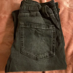 Svarta jeans från Gina Tricot - Snygga svarta jeans från Gina Tricot med klassisk femficksdesign och knappgylf. Perfekta för en stilren look.