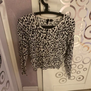 Leopardmönstrad kofta med knappar - Snygg leopardmönstrad kofta med knappar framtill.  Koftan har långa ärmar och en rund halsringning.