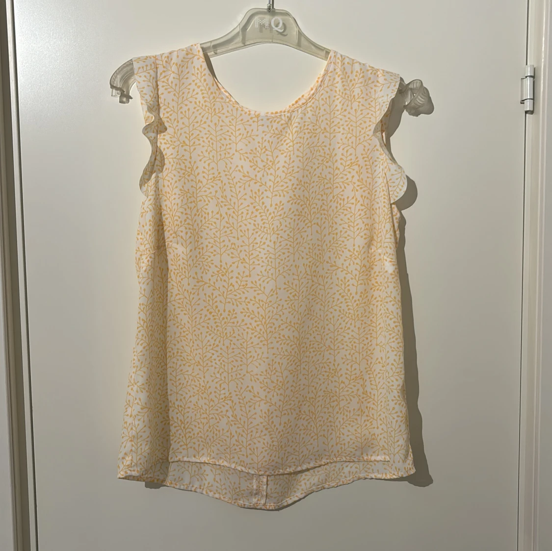 Gulmönstrad blus med volangdetaljer