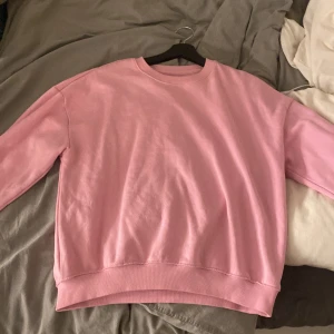 Rosa sweatshirt från lager 157 - Mysig rosa sweatshirt från lager 157 i storlek S. Perfekt för en avslappnad stil med ribbade muddar vid ärmslut och nederkant. Enkel och stilren design som passar till många tillfällen.