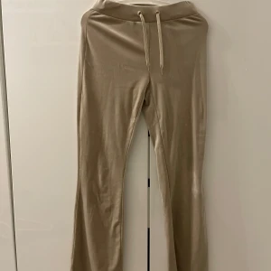 Beige mjukisbyxor med snörning - Säljer ett par bekväma beige mjukisbyxor med snörning i midjan. Byxorna har en avslappnad passform och två bakfickor. Perfekta för en chill dag hemma eller en avslappnad utflykt.