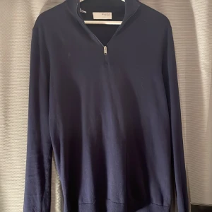 Mörkblå tröja med dragkedja från Selected Homme - Snygg mörkblå tröja från Selected Homme med dragkedja vid halsen. Perfekt för en stilren look. Tröjan har långa ärmar och en enkel design som passar till många tillfällen.