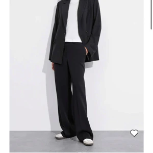 Svarta &Other stories byxor - Säljer ett par stilrena svarta byxor med pressveck i nyskick . De har en vid passform som ger en elegant look, perfekt för både vardag och fest. Byxorna är tillverkade i ett bekvämt material som faller snyggt.