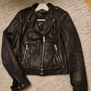 Äkta skinnjacka Jofama  - Supersnygg och tuff skinnjacka i äkta läder (se lappar). Jackan har ett dekorativt innertyg och unika detaljer. Designad av Marie Serneholt för JOFAMA. Nypris 2999:-