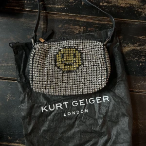 Kurt Geiger Smiley Party Bag med dustbag  - En helt otrolig väska från Kurt Geiger som inte går att få tag i längre. Med hundratals handsydda glittriga strassdetaljer blir det en perfekt partyväska.   ✨✨  Nyskick, endast använd en gång på ett bröllop. 