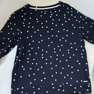 Elegans Sweatshirt, från Gant. - En helt ny Gant Sweatshirt i elegant mörk blå färg med vita prickar. Längden är 58 och beredd 47 Cm  Denna tröja är i storlek S och är helt ny och utan prislapp.  Ordinarie pris är 1199 kr, men du kan nu få  den till ett fantastiskt pris  endast 349.