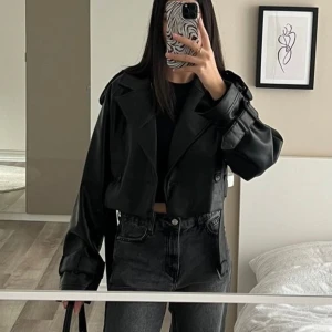 Skinnjacka  - Kort skinnjacka med bikerdetaljer, helt ny med prislapp. Storlek 38