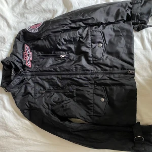Jacka  - Väldigt snygg oanvänd Calvin Klein jacka. Svart på utsidan med lite markeringar och illröd insida. Många fickor. Lite fodrad.  Säljer då den inte kommer till användning. 