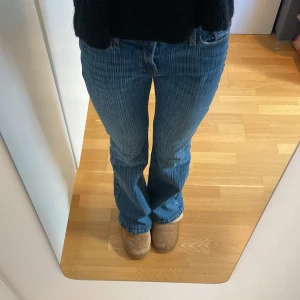 Brandy Melville Jeans - Snygga brandy bootcut low waist jeans i bra skick. Säljer för att de tyvärr är för stora. Randigt jeans material. Köpta för ca 500kr.