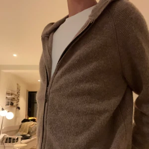 Luvtröja Brun/Beige  - Hej jag säljer nu min luvtröja tillverkad av 100% högkvalitativ ull. Tröjan är i storlek S men kan även passa som M. Skick 9/10 Nypris är 1400,tröjan är även lite ljusare än på bilderna. Skriv för fler frågor