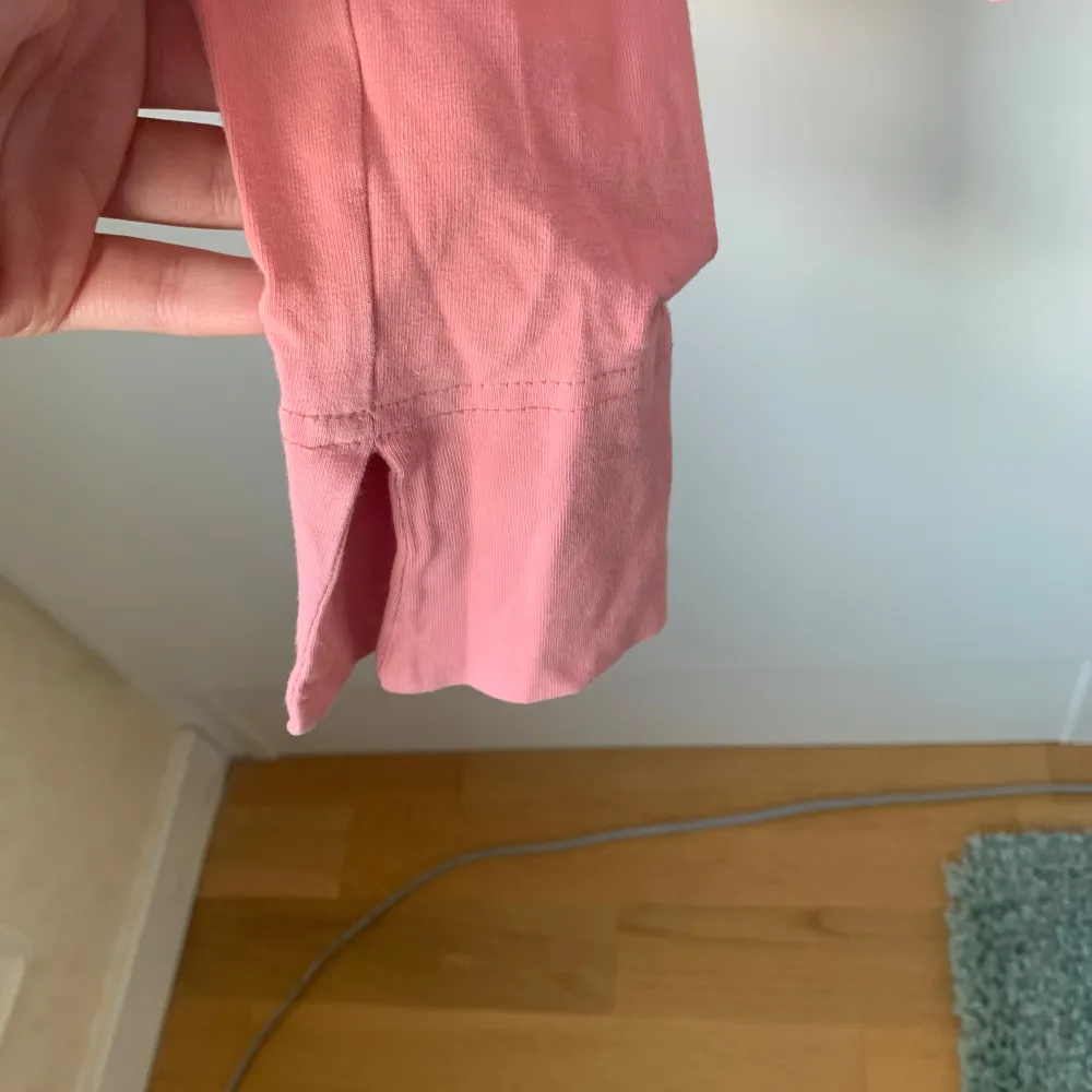 Rosa v-ringad långärmad tröja med slits på ärmarna. Yläosat.