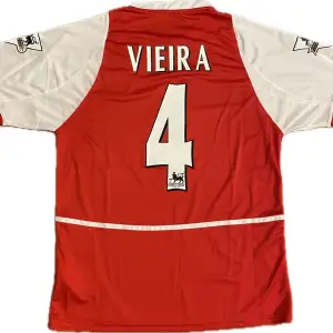 Säljer en fotbollströja från Arsenals säsong 02/03 med Vieira #4 på ryggen. Lite ”skitig” O2-logga som är svår att få med på bild. Det är en reprint. Storlek: L. Ansvarar ej för postens slarv. Endast handtvätt. Gnugga ej på blöta prints.